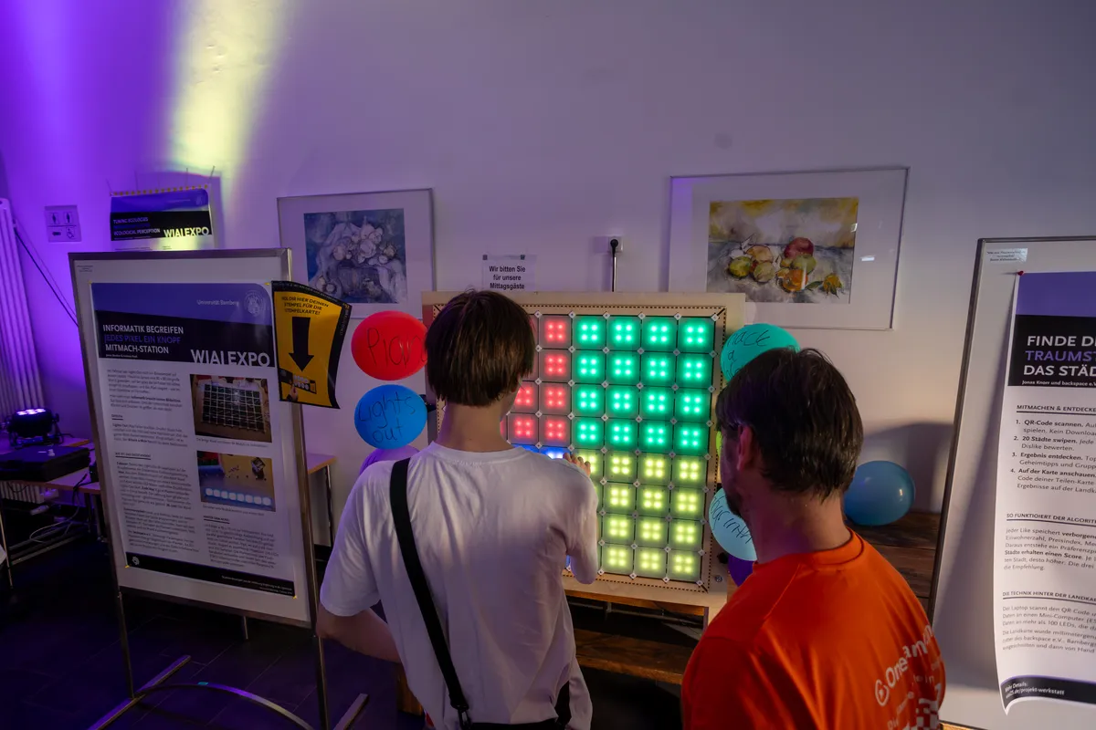 Visitors playing at the LED gaming wall at the WIAI25 celebration